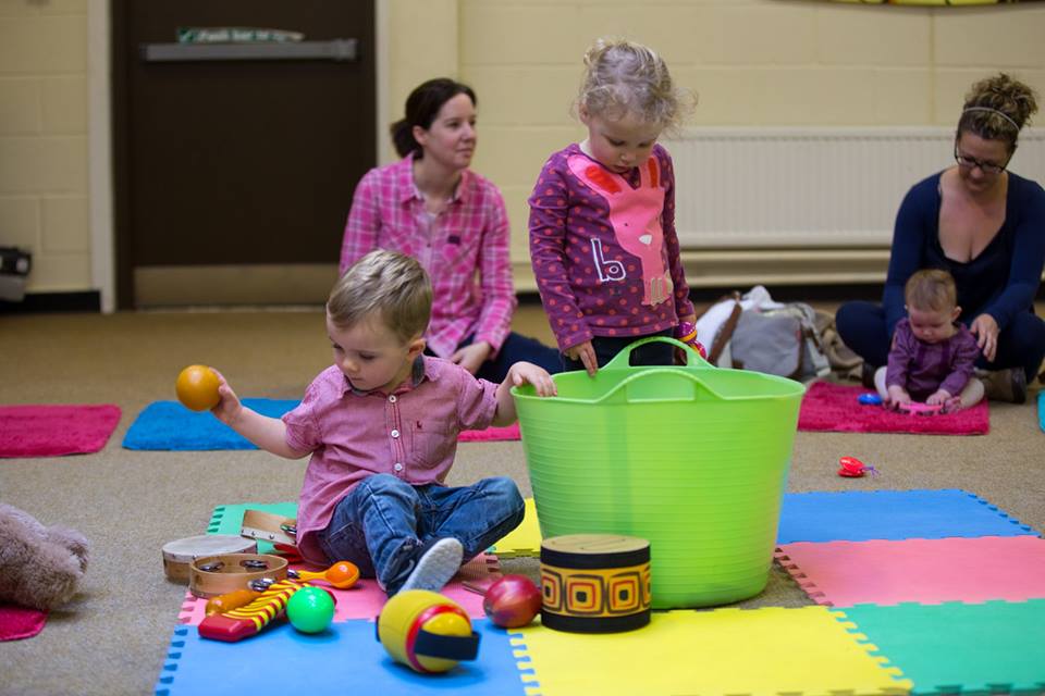 Image shows parents and toddlers enjoying Music Bugs class